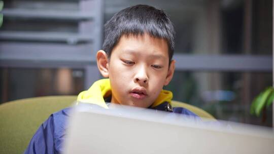 男孩子在家里使用笔记本电脑上网