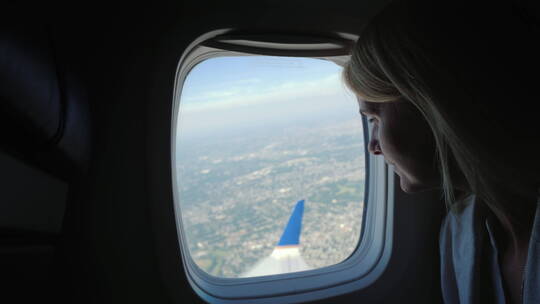 女乘客望向窗户外的景色