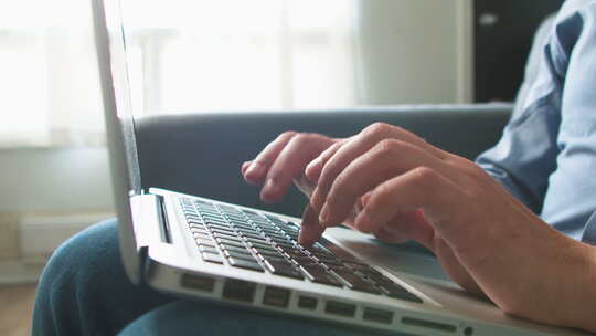 男人的手在电脑键盘上打字的特写