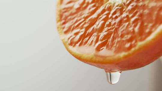 一滴果汁从一个美丽多汁的橘子的边缘落下。
