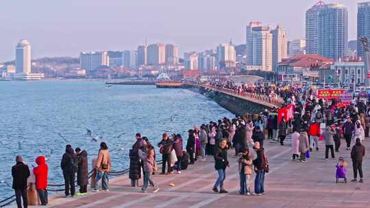 海滨步道上的人群与城市建筑景观