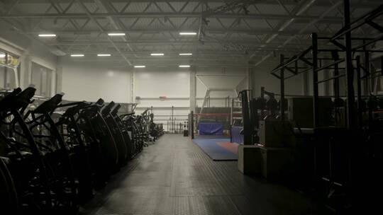 在空荡荡的健身房打开灯。黑暗的健身房背景