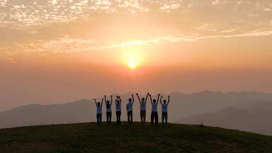 夕阳下欢呼招手团队青年希望梦想创业团队