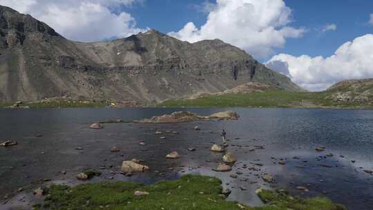 一个人站在山湖的岩石上