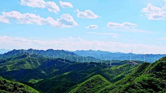 夏季绿色高山蓝天白云与风力发电机组