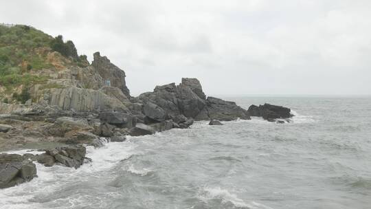 海边浪花拍打礁石，沙滩