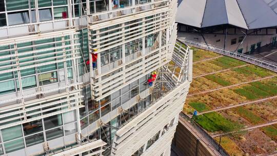 4K航拍高空作业工人蜘蛛人工地劳动擦玻璃
