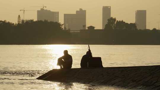 夕阳西下河岸边钓鱼的人视频素材模板下载