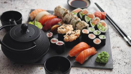 各种不同种的寿司卷放在黑色石板上