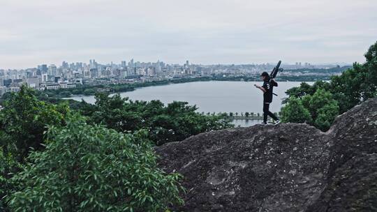 小轮车手在宝石山上俯瞰杭州城市