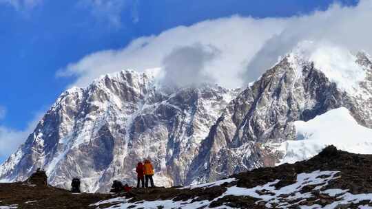 航拍垭口观看贡嘎山区雪山群峰的徒步旅行者