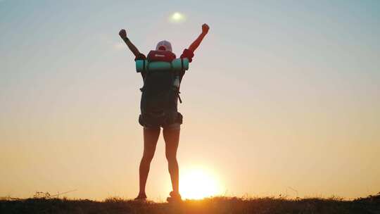 女人登上山顶张开臂膀欢呼庆祝