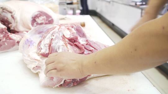 现代商超生鲜工作人员切割猪肉