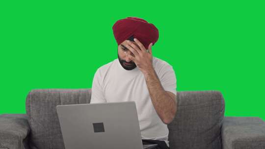 困惑的锡克教印度人使用笔记本电脑绿屏