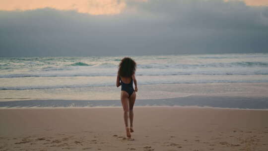 背影女人跑向海浪远处的夏夜