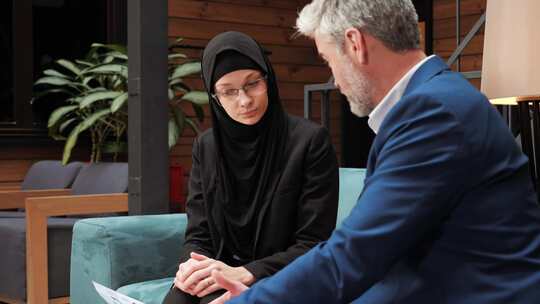严肃的商业穆斯林阿拉伯女人说话倾听她的商业伙伴