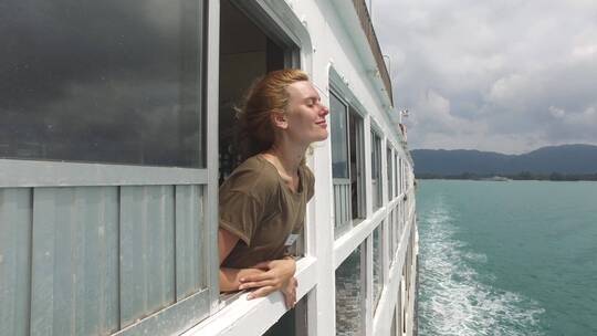 女孩在一艘大船上享受大海海风