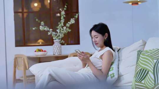 居家女子沙发上玩手机画面