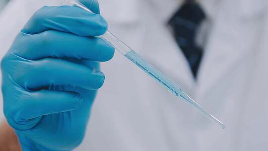 研究员在实验室将蓝色液体滴入试管