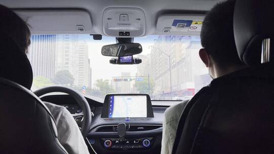 网约车司机按照手机上导航行驶在城市道路上视频素材模板下载
