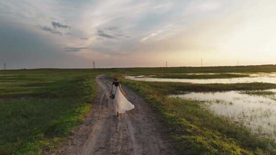 少女行走在内蒙古大草原的土路上