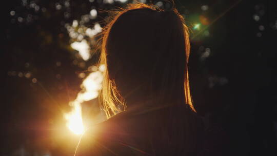 女孩在公园看日落剪影