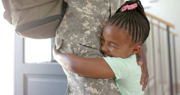 非裔美国女儿拥抱穿着军装的父亲