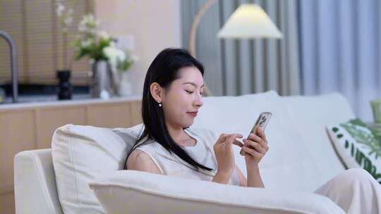 居家女人坐沙发看手机素材