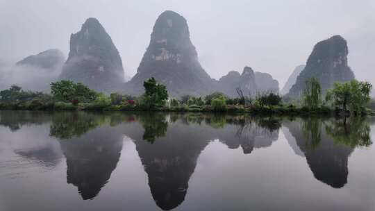 雨天湖景倒映绿树青山的宁静画面