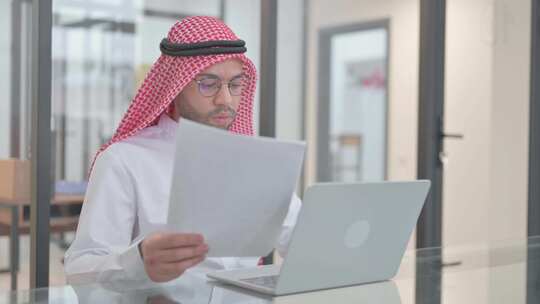 年轻的阿拉伯男人在工作中一心多用