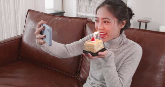 美女开心居家过生日拿着手机和朋友视频聊天