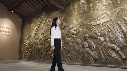 红色家风馆女子参观革命主题浮雕场景