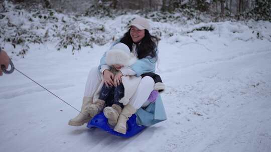 母亲和女儿在雪橇上