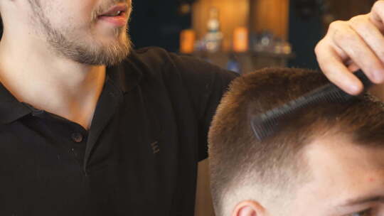专业男发型师在时尚理发店为顾客梳理头发的特写镜头