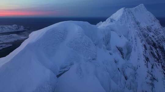 在夜空下滑翔在挪威白雪覆盖的山峰上