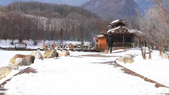 冬天湖北旅游神农架林区雪地木屋行走的人