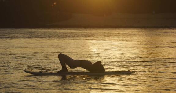 湖中桨板上练瑜伽的女人
