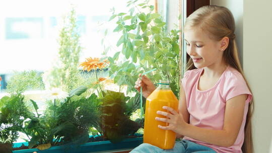 女孩用吸管喝大瓶橙汁