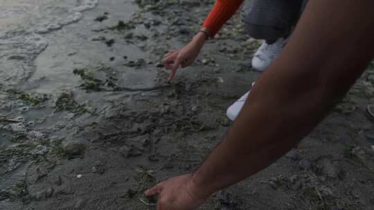 男人和女人在海滩的沙滩上写字