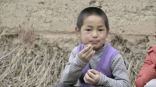 在田间吃东西的小孩子