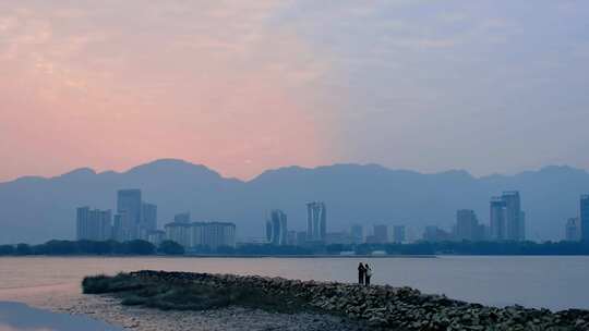 水边城市暮色中两人赏景