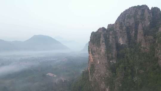 无人机向老挝冒险之都万荣笼罩在雾中的悬崖