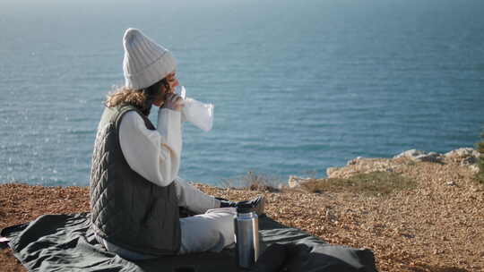 独自在悬崖边吃海洋野餐的女孩视频素材模板下载