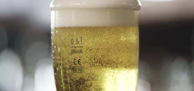 泡沫覆盖在啤酒上，慢慢落到玻璃杯的侧面