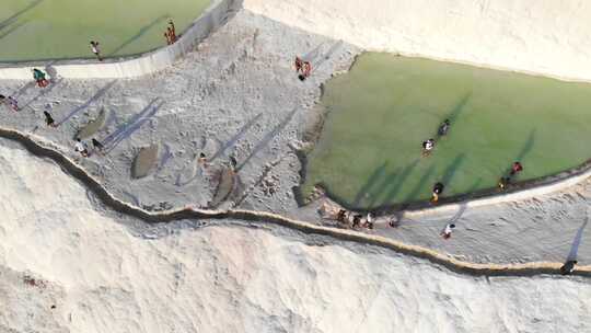 游客和游客在帕穆卡莱的碳酸钙石灰华上散步