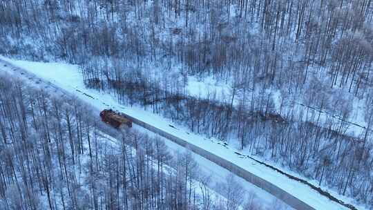 行驶在林海雪原山路上的货车