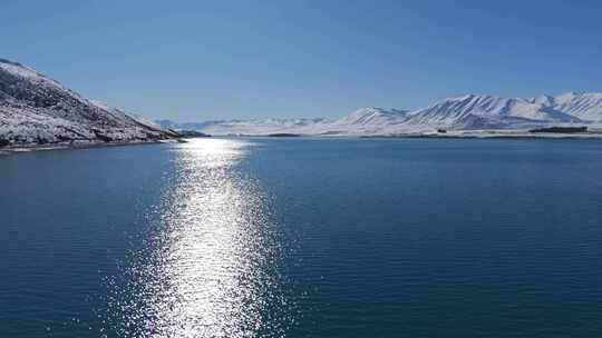 美丽的湖景被令人惊叹的白雪覆盖的山脉环绕