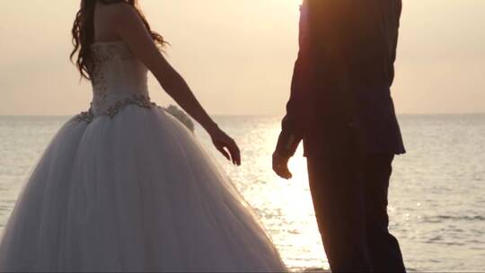 新婚夫妇在海边手牵手