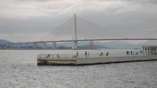 游客在海湾亲水平台眺望大桥打卡拍照