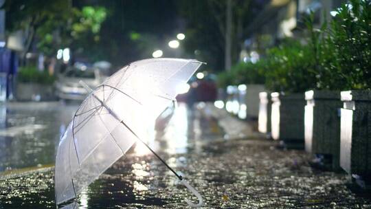 雨中的雨伞放在路边，车来车往